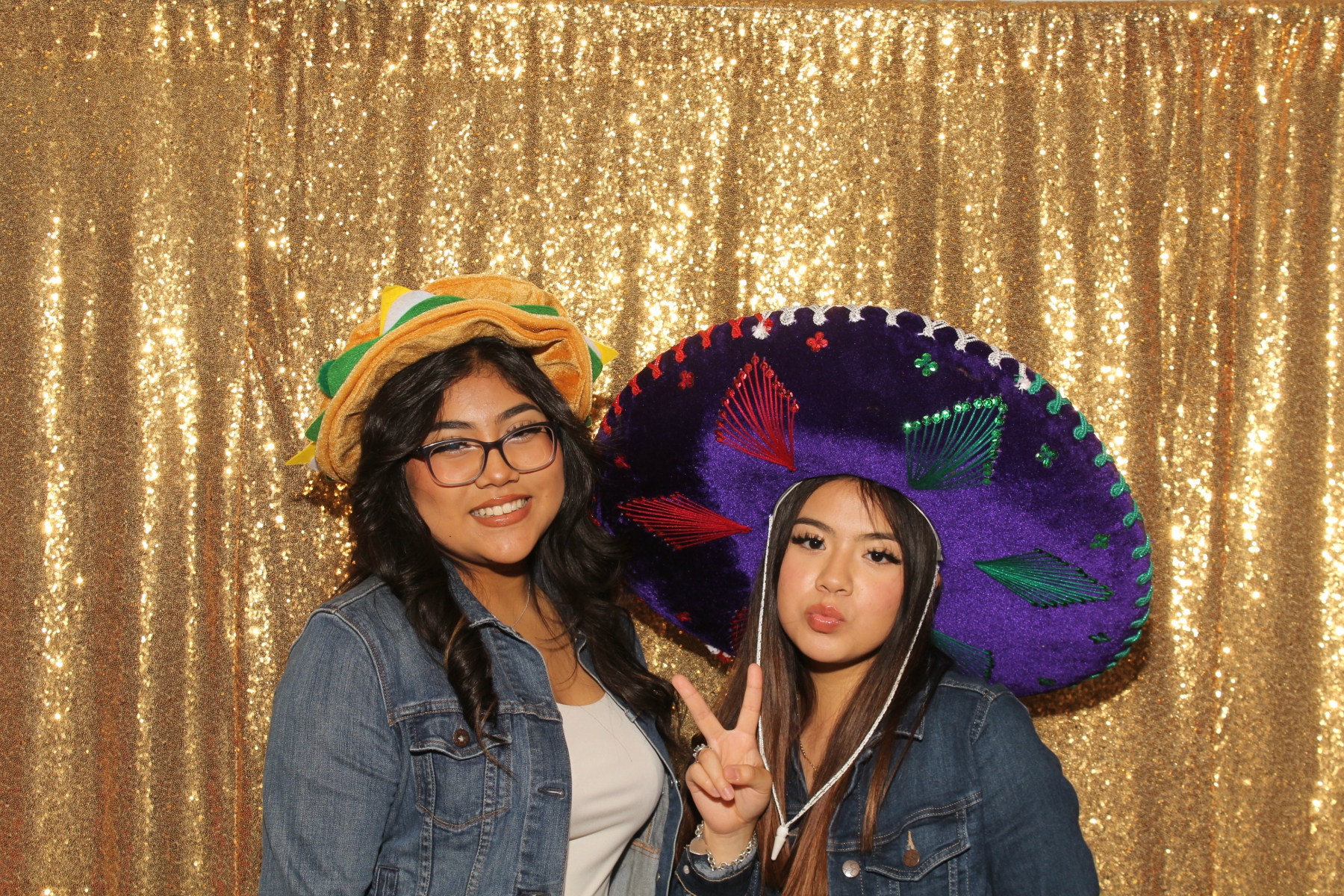 Wedding guests posing with themed props at reception photo booth