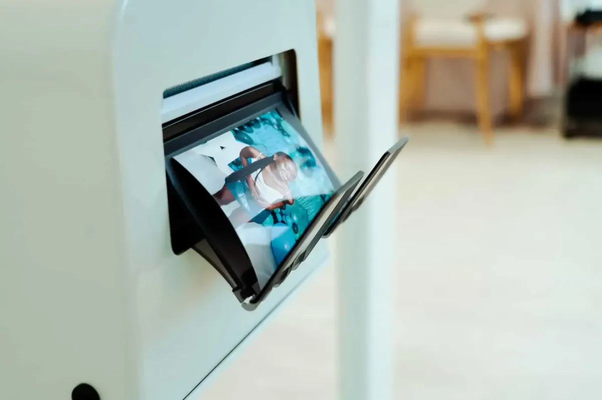 A photo prints out of a white printer, showing a candid image partially visible—a delightful moment captured with a Photo Booth Rental from DC.