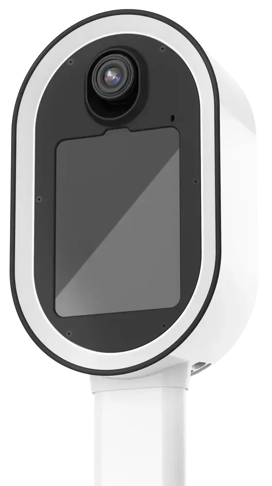 A white security camera with a black faceplate and lens is mounted on a white stand against a neutral background, capturing every detail as if it were creating a crisp photo booth print.