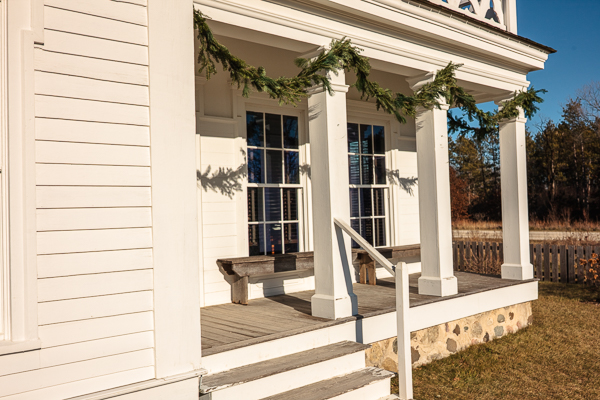 Covered porch at Old World Wisconsin of the Yankee Home, decorated with pine boughs for the holiday season