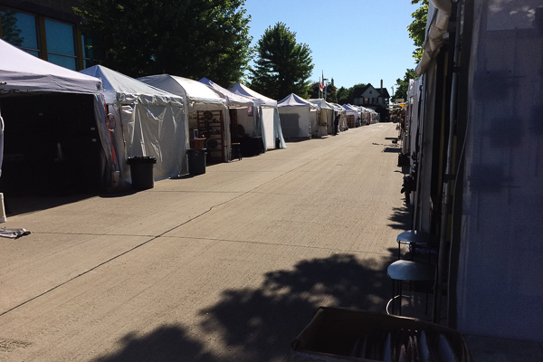 Art fair tents in a row on a street early morning before the show starts