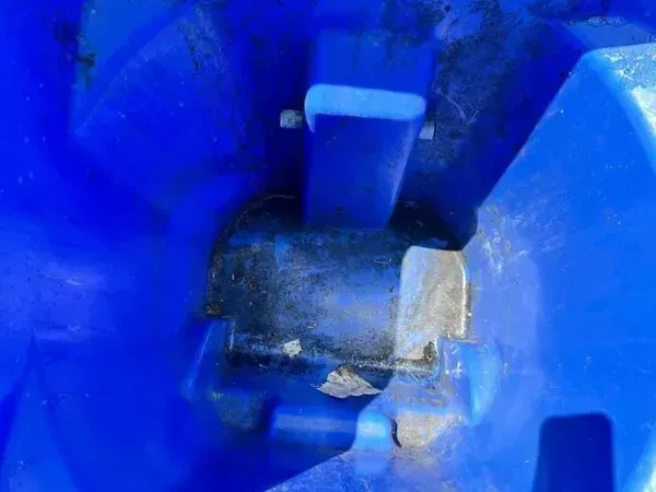 Dirty blue trash bin before cleaning.