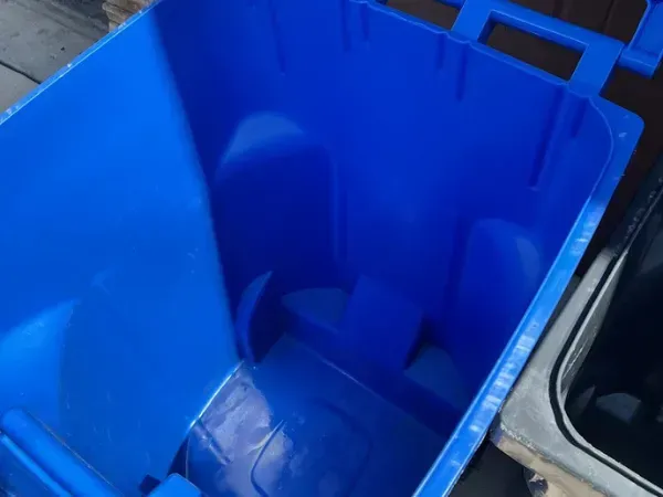 Clean blue trash bin after professional washing.