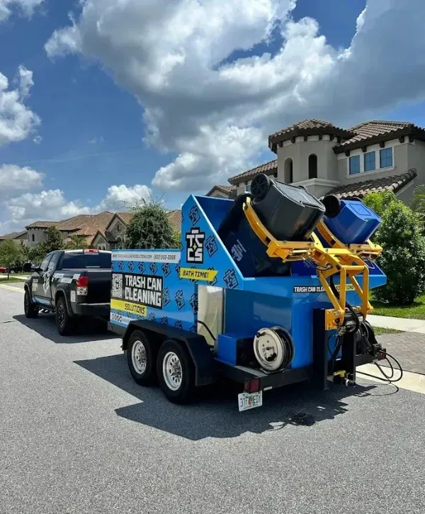 Trash can cleaning truck with bins being washed in a residential neighborhood