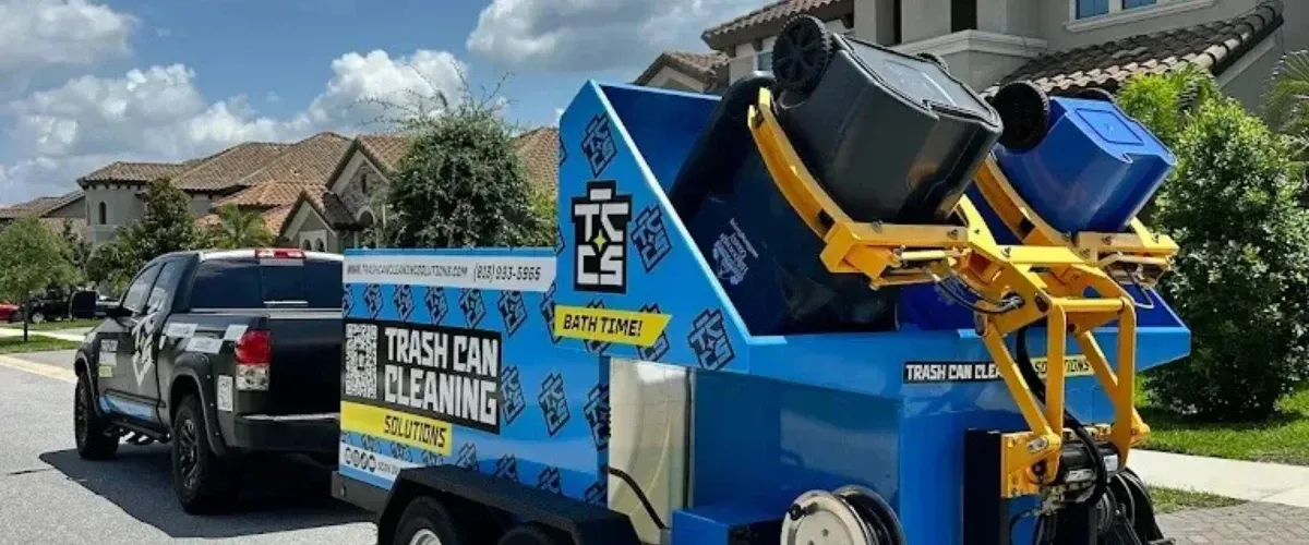Trash can cleaning truck washing garbage bins on residential street