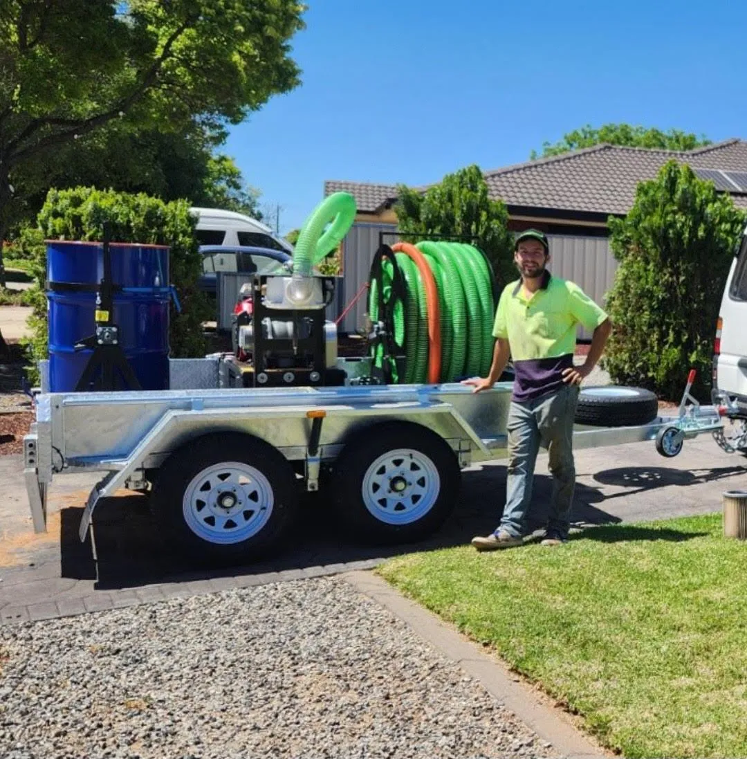 Mike Marrable from Mike's Window, Gutter, and Solar Cleaning, standing outdoors with solar panels and a palm tree in the background, showcasing professional cleaning equipment in Mildura, Sunraysia region.