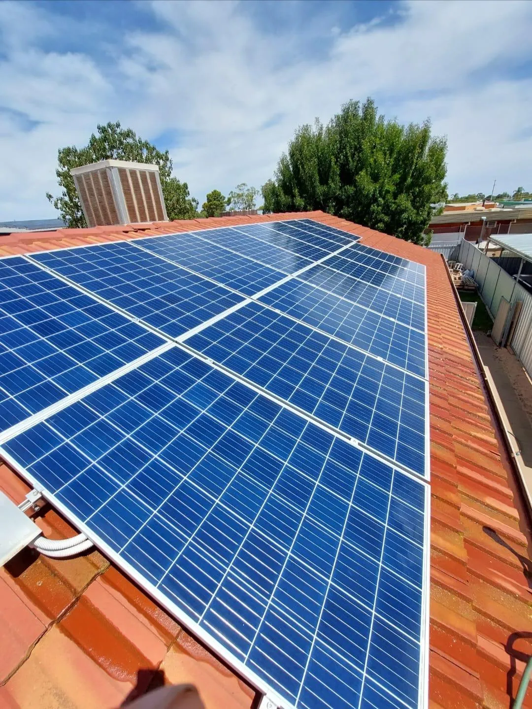 Clean rooftop solar panels installed on a terracotta tile roof under clear blue skies in Mildura, Victoria.