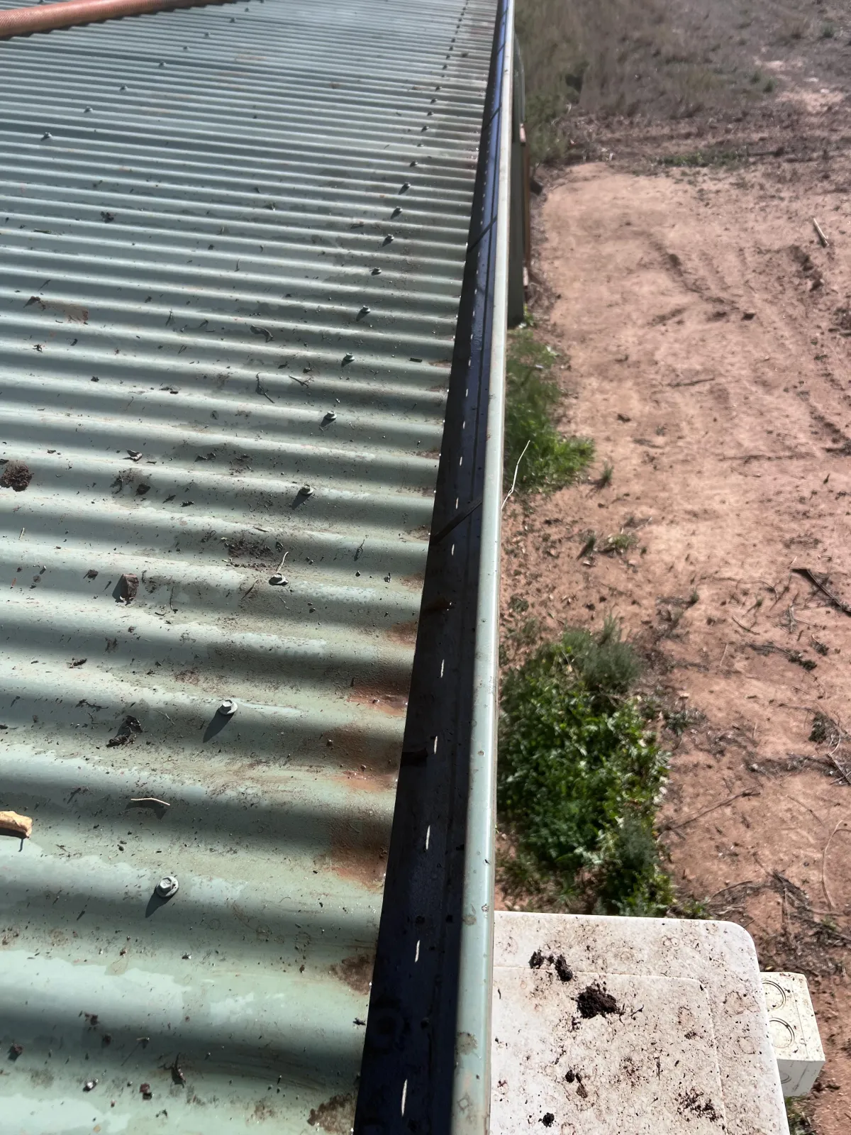 reshly cleaned roof gutter in Mildura with all debris removed and clear water flow restored.