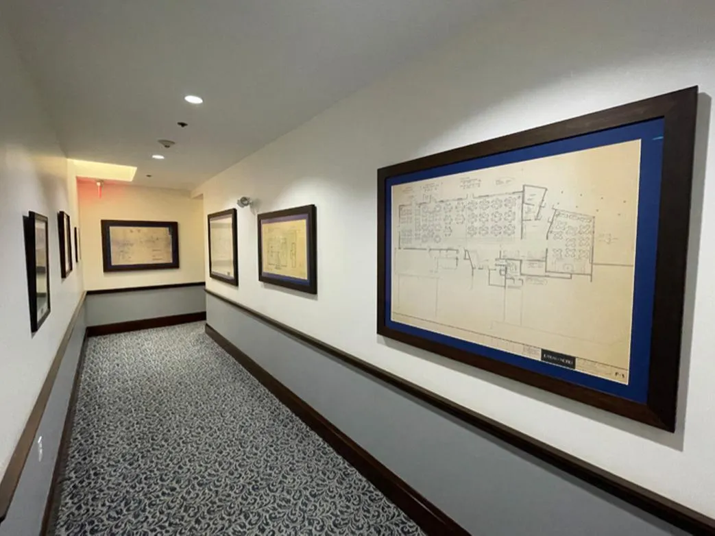 Framed artwork displayed in hallway with custom picture framing by The Beacon Studio Winthrop MA