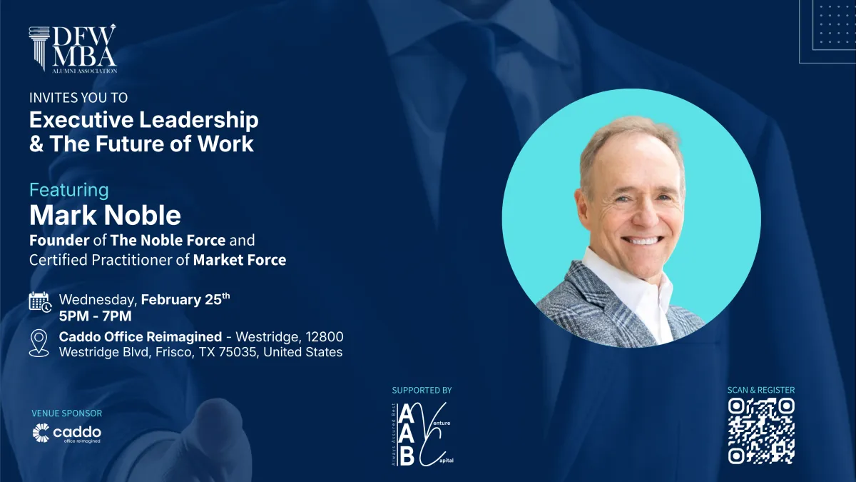 A candid photo of a bustling indoor event with people browsing art displays, vibrant banners overhead, and a stage in the background.