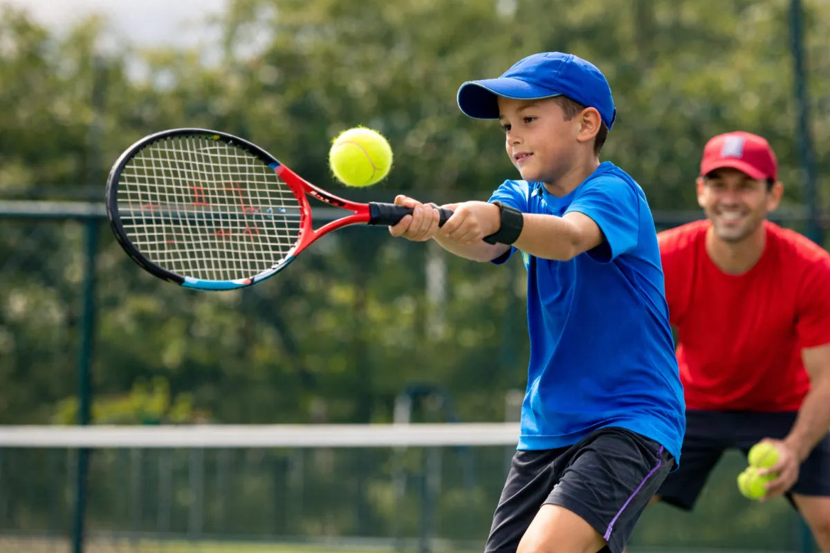 a man hitting a tennis ball with a racket