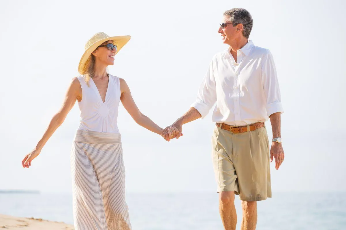 Middle-aged man and woman enjoying life at the beach because of alternative medicine