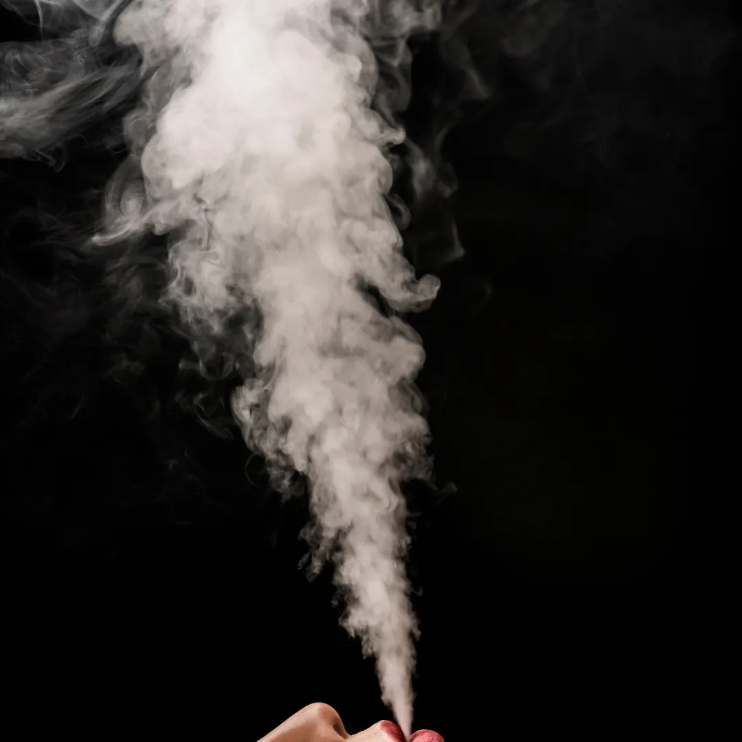 A lady blowing smoke