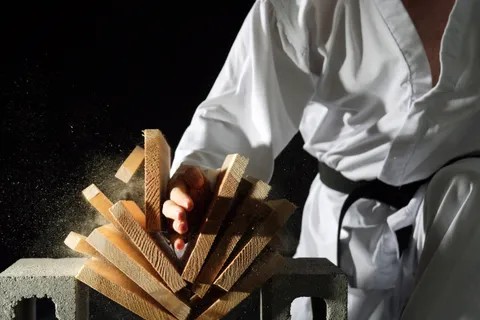 A man laying on the ground with a flower in his hand