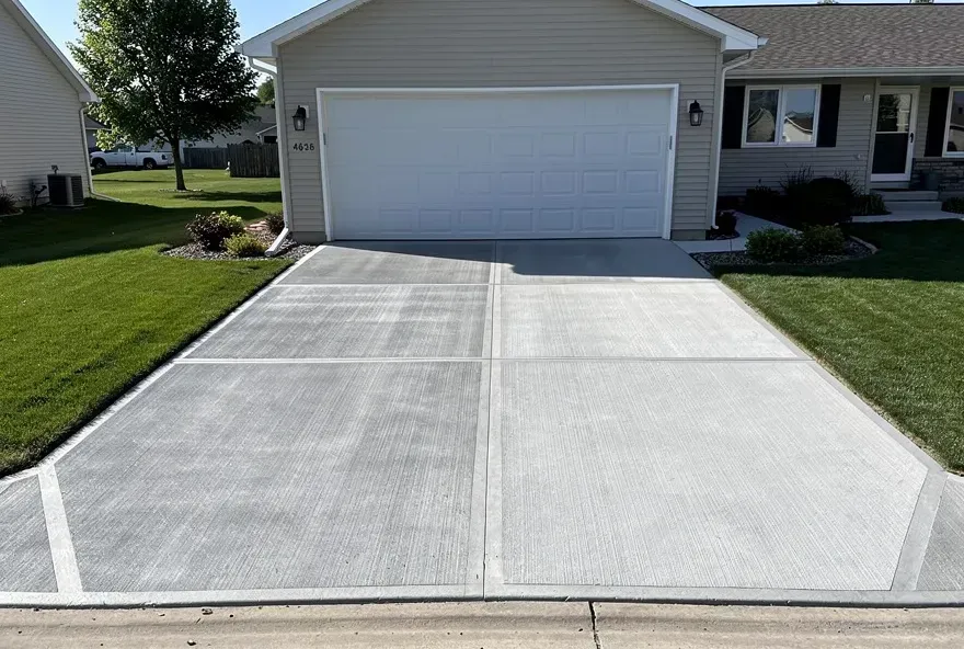 Newly finished concrete driveway attached to garage door at a home in Beloit, Wisconsin.
