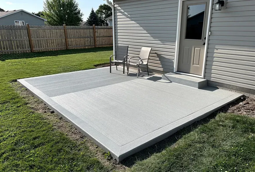 Freshly finished concrete patio attached to the back of a home in Beloit, Wisconsin on a sunny day.