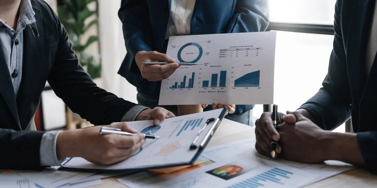 people holding document with graphs on them