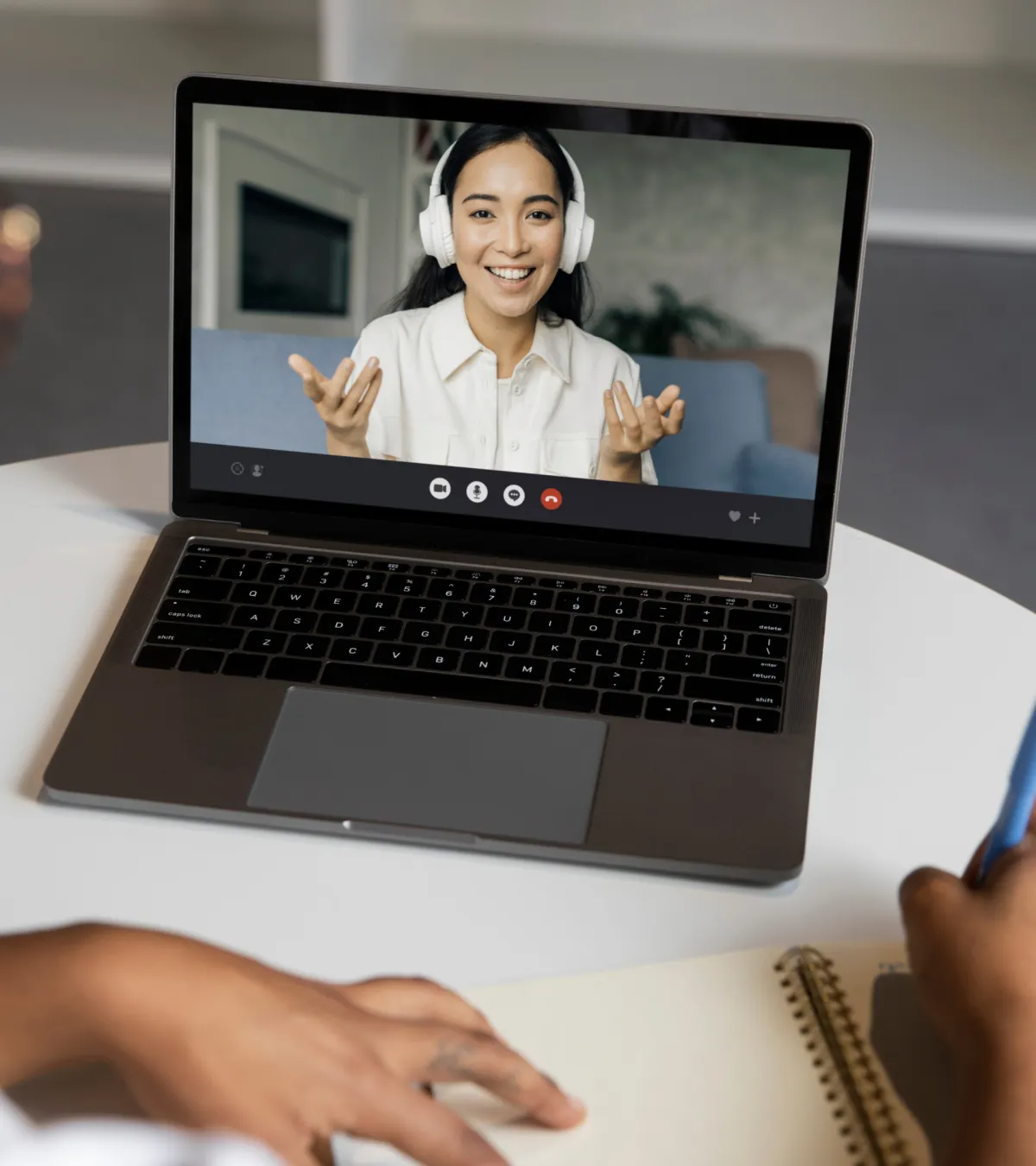 Person taking notes on a laptop during a 1:1 business coaching video call, improving skills and strategy