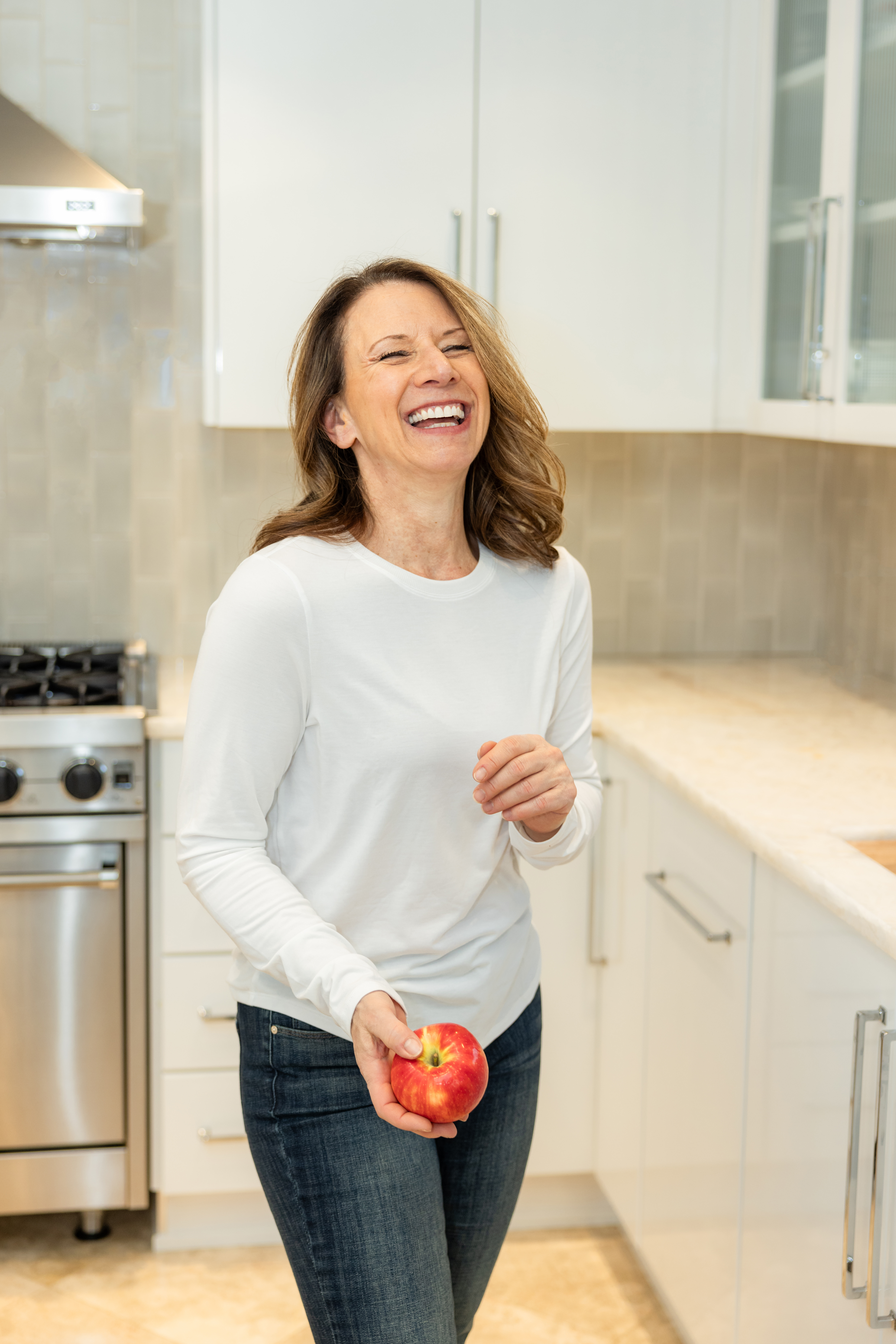 Maria Rigo seated at the top of the table smiling with some vegetables on the side