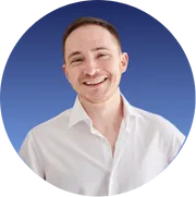 A confident small business owner stands in a modern workspace, reviewing a digital marketing dashboard on a laptop. The background features subtle branding elements in blue and teal, evoking a sense of professionalism and growth. The scene is bright, inviting, and energetic, with a focus on empowerment and success.