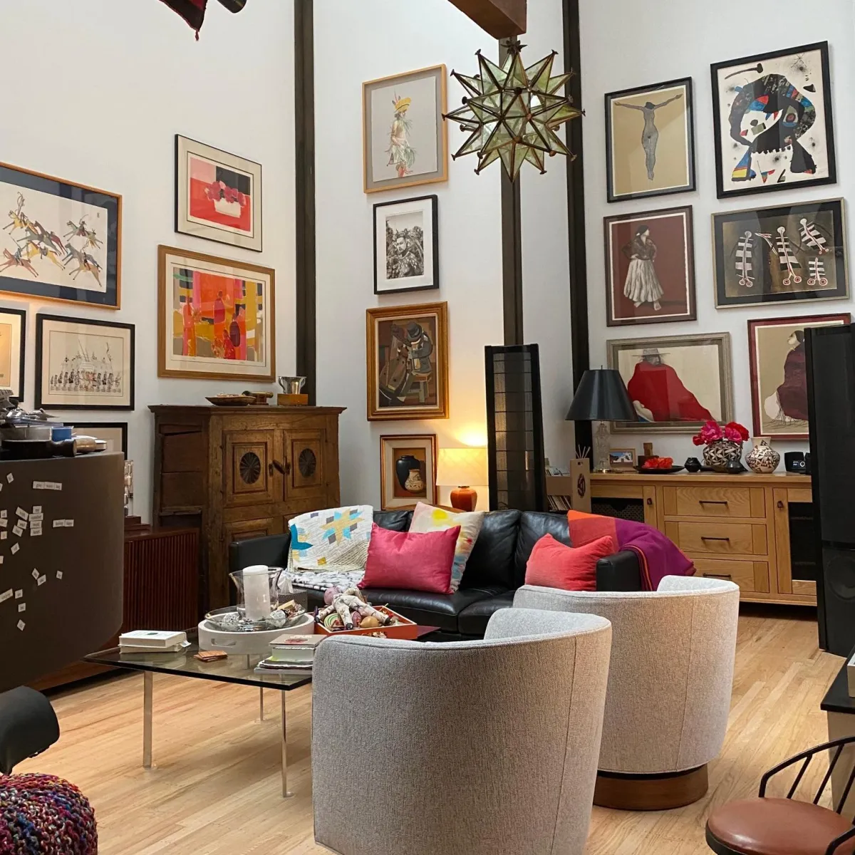 Large residential gallery wall installation with professionally arranged framed artwork throughout an open living space