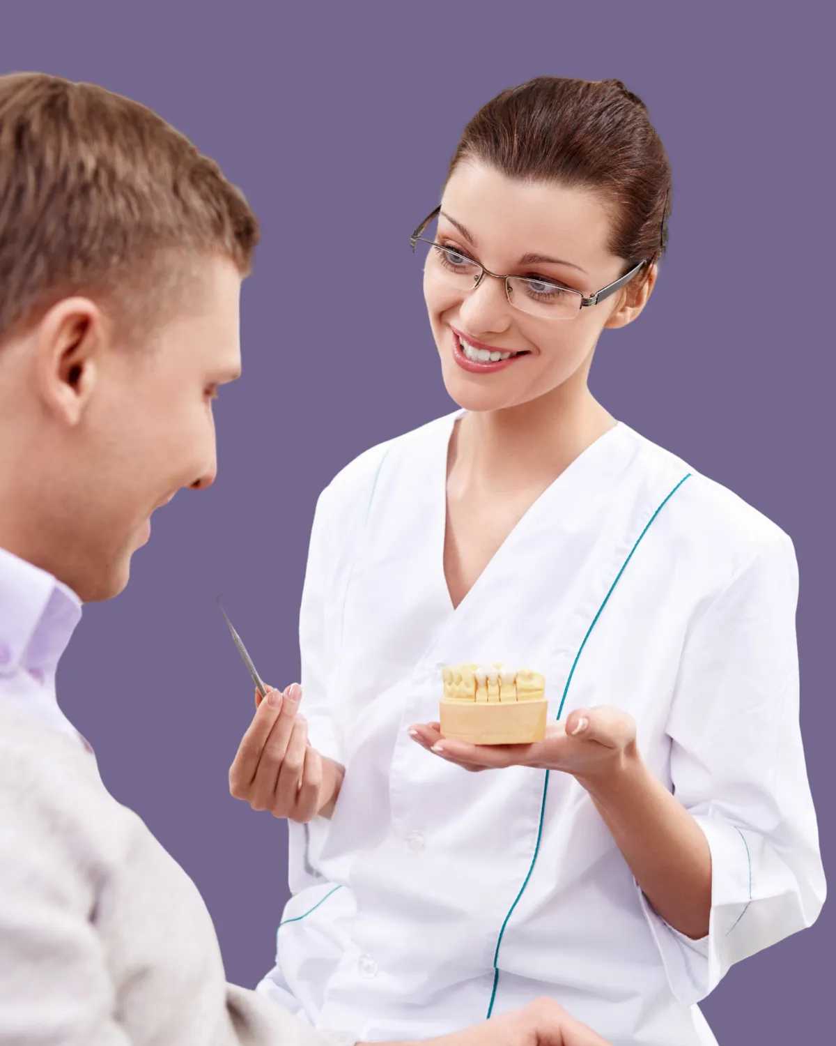 Dentist showing patient dental crowns and bridges during dental surgery consultation.