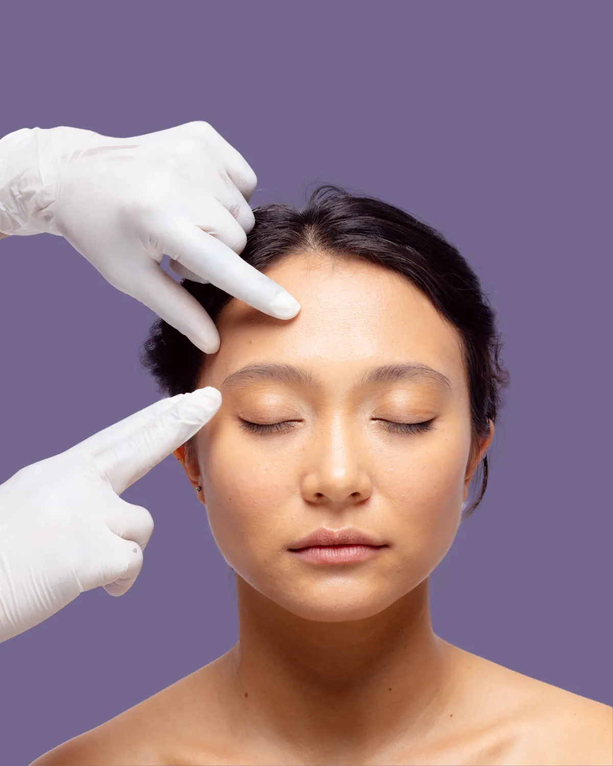 Surgeon marking patient’s eyelids for facial plastic surgery to enhance eye appearance.