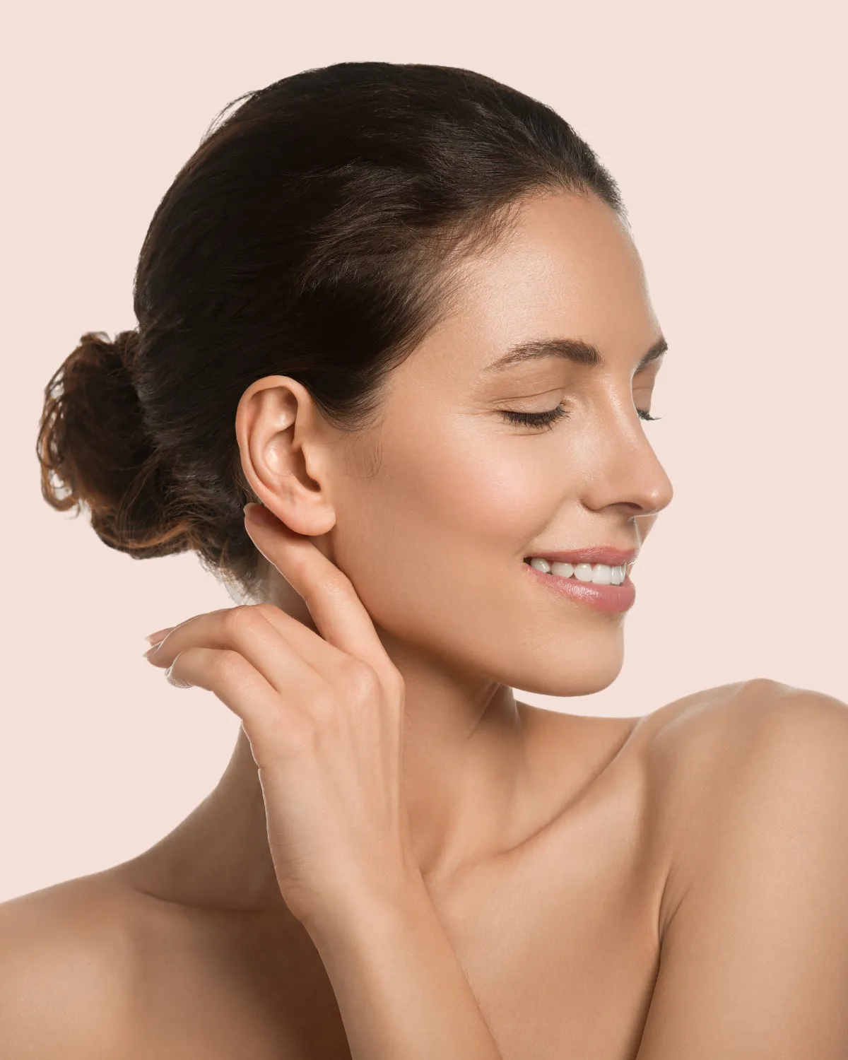 Woman touching ear after facial plastic surgery correction.