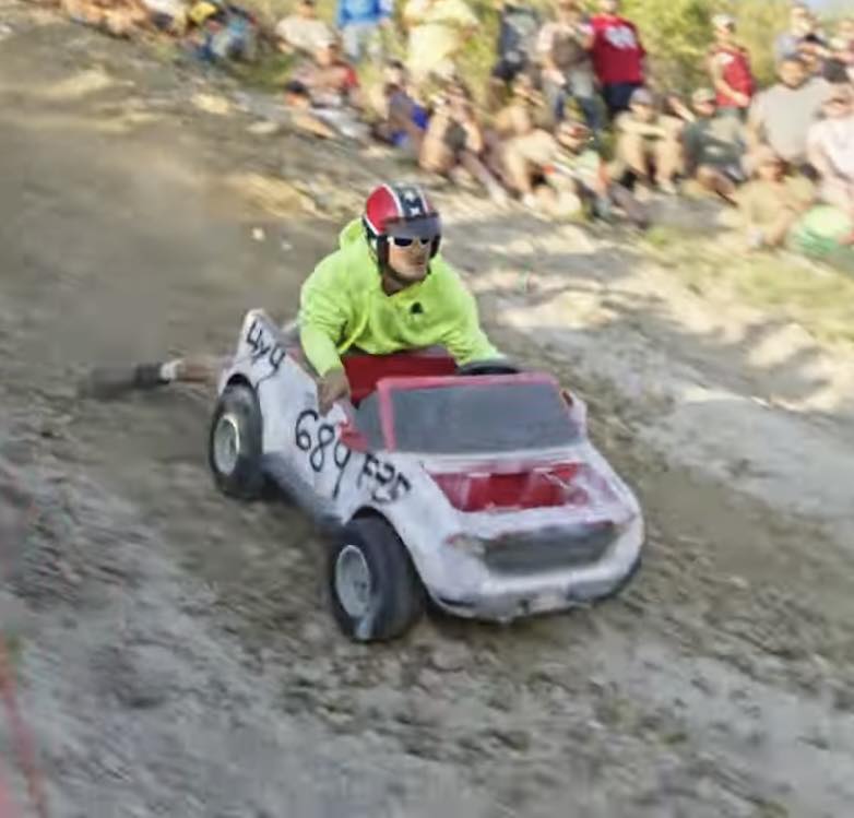 Mud truck splashing through deep mud pit at Miller Mud Boggs
