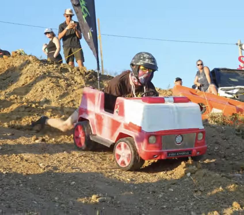 Mud truck splashing through deep mud pit at Miller Mud Boggs