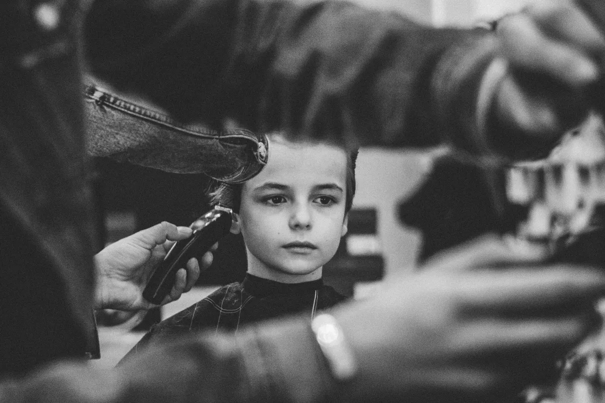 man in white dress shirt cutting hair of man