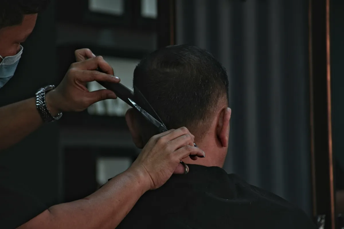 A man getting his hair cut in a barber shop