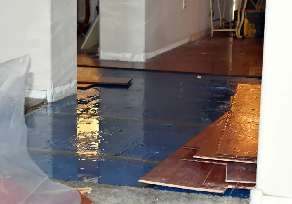 Flooded interior room with standing water and damaged flooring.