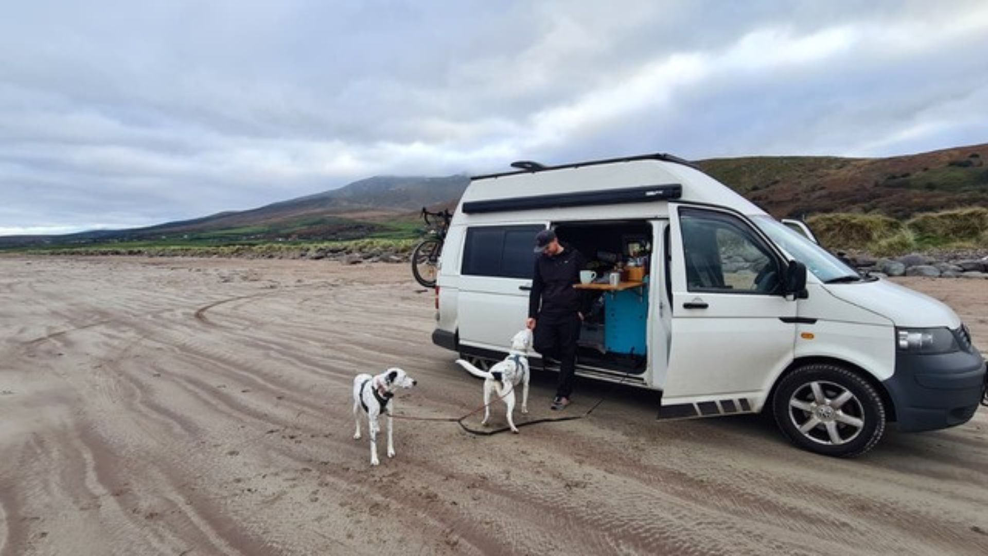 Vanlife mit Hund in Europa. Chris mit den Hunden Mia und Maya vor dem VW T5 Camper Pepe in Norwegen. Reisen, Freiheit und Abenteuer auf vier Rädern.