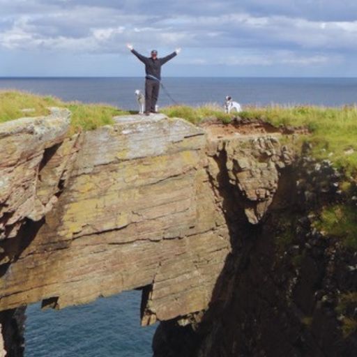 Chris auf einer spektakulären Felsformation an der schottischen Küste. Roadtrip durch die Highlands mit Wanderungen, Küstenlandschaften und versteckten Naturhighlights in Schottland.