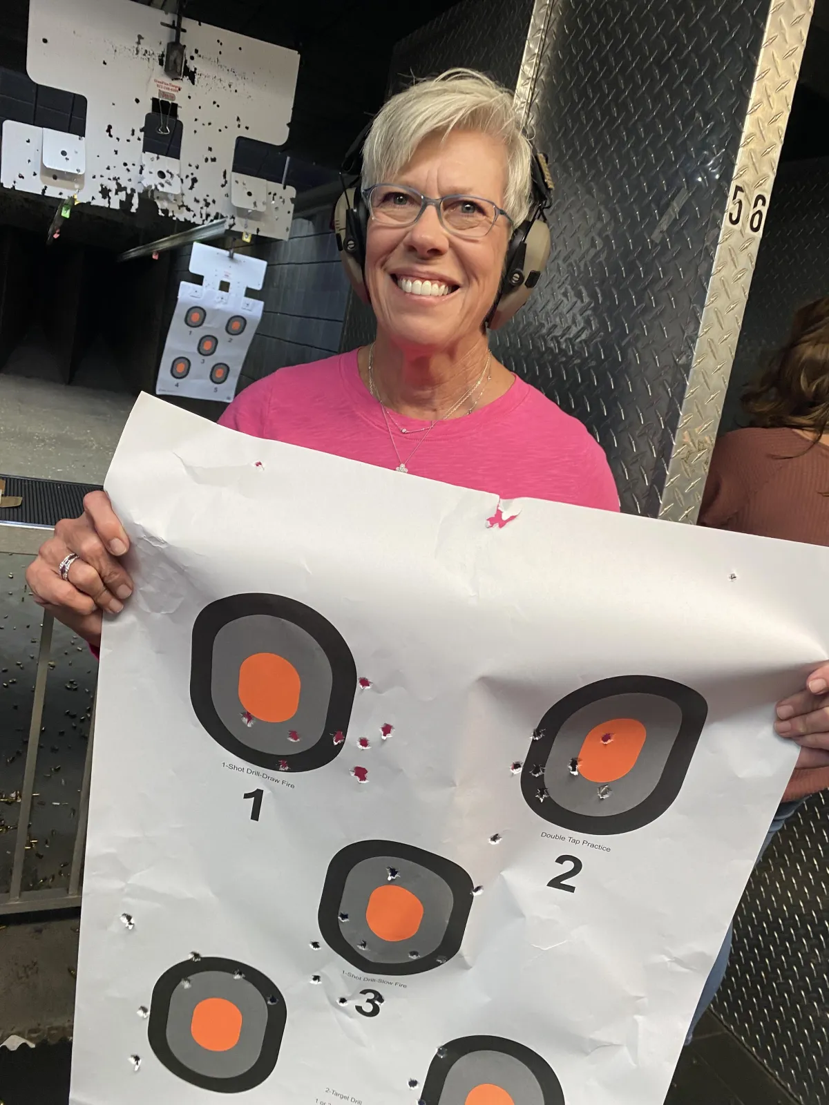 Female student holding target at gun range