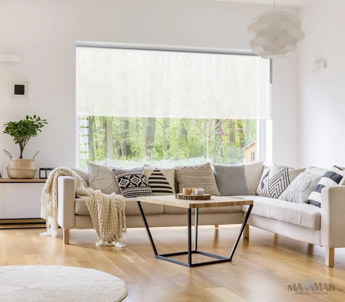 Maxxmar roller shade installed in a living room window allowing a transparent view of the outside and UV protection for the inside furniture and flooring.