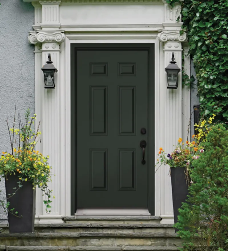 A traditional dark grey entry door made of steel with white architecture.