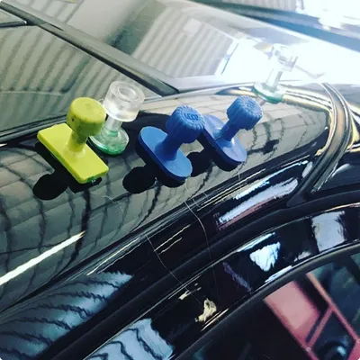 Precise Dent Repair Technician repairing car dent without repainting panel