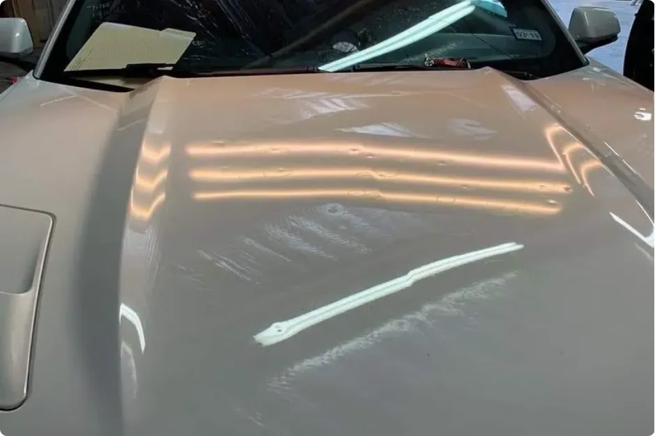 Technician repairing car dent without repainting panel