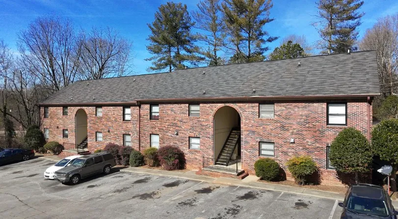 Red brick multifamily building, the kind of property an accredited investor might invest in through a syndication
