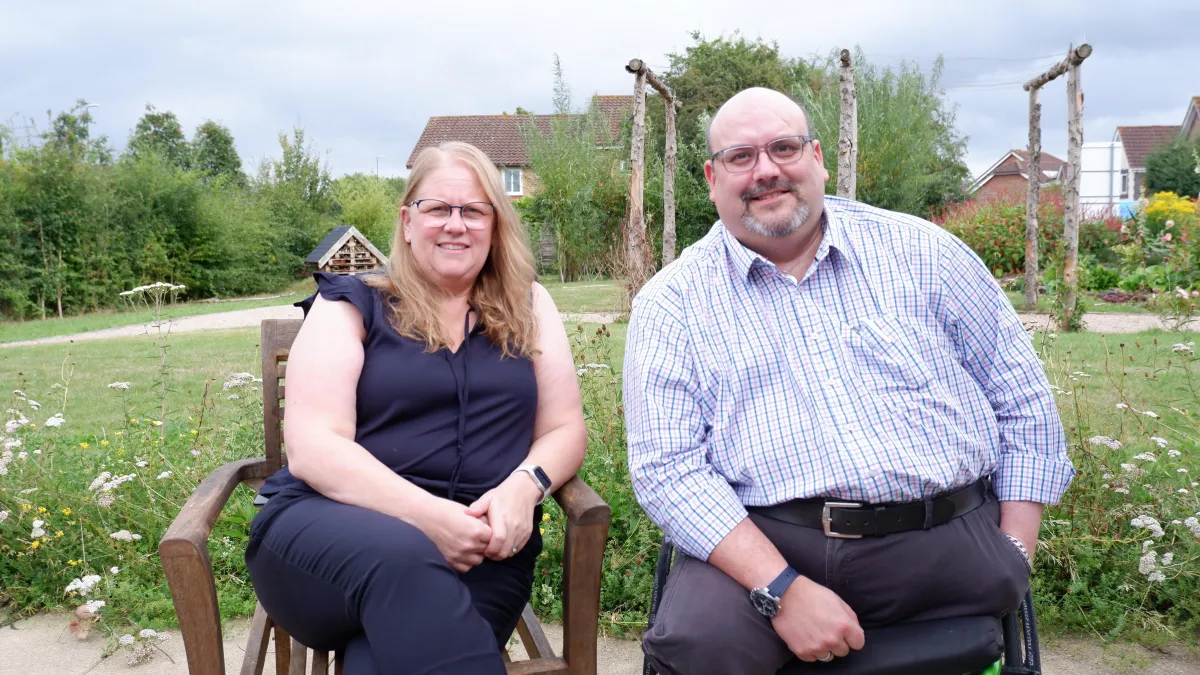 Lucy Smith, a woman with blond hair sitting on a chair and Dan Biddle man with a beard and glasses sitting in a wheelchair