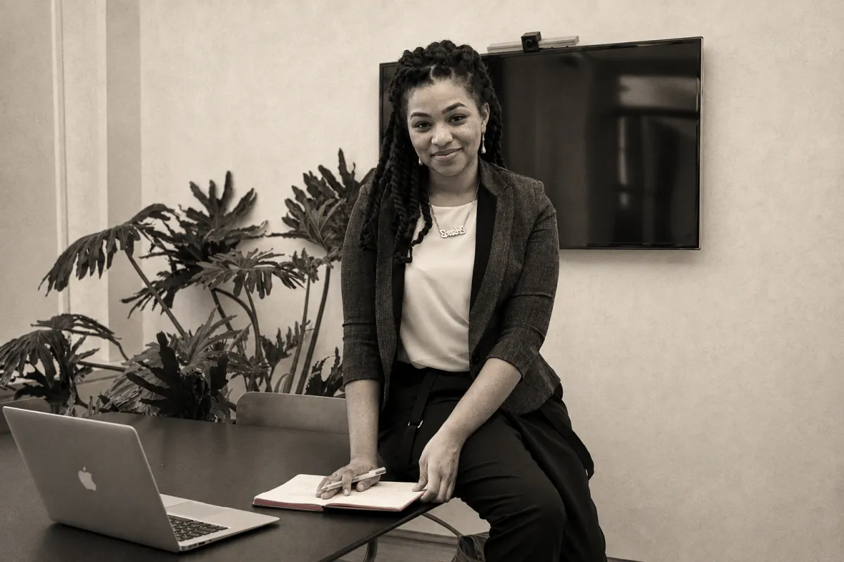 A Black woman professional planning her next career move with a notebook and laptop in a warm editorial monochrome photograph.