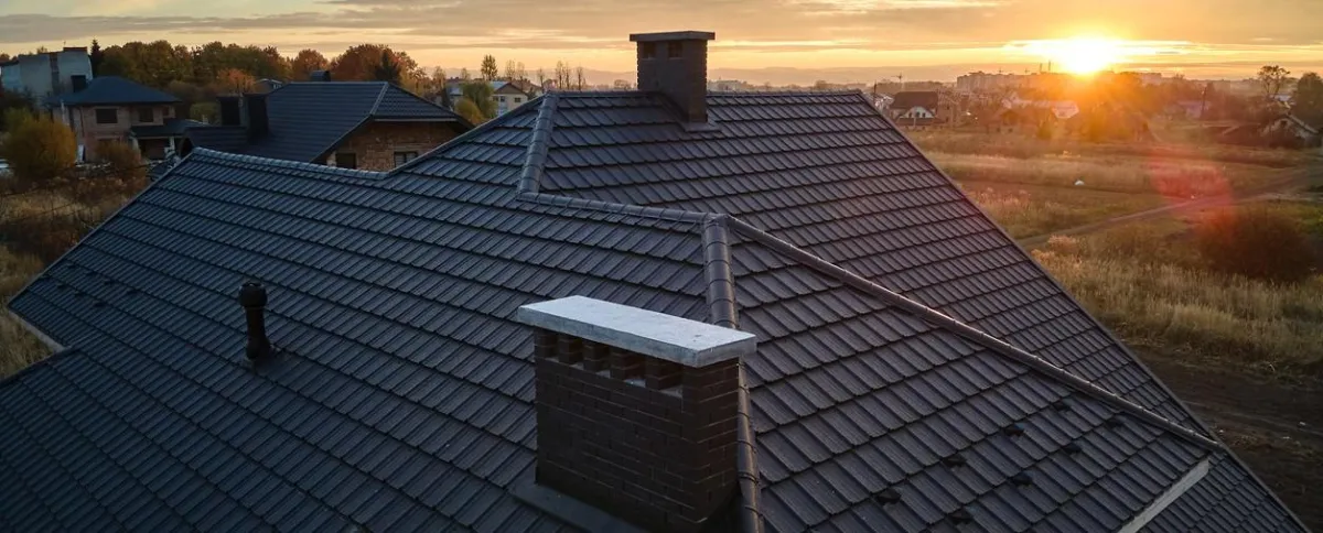 Residential roof with durable tiles at sunset, showcasing expert roofing solutions by  in .