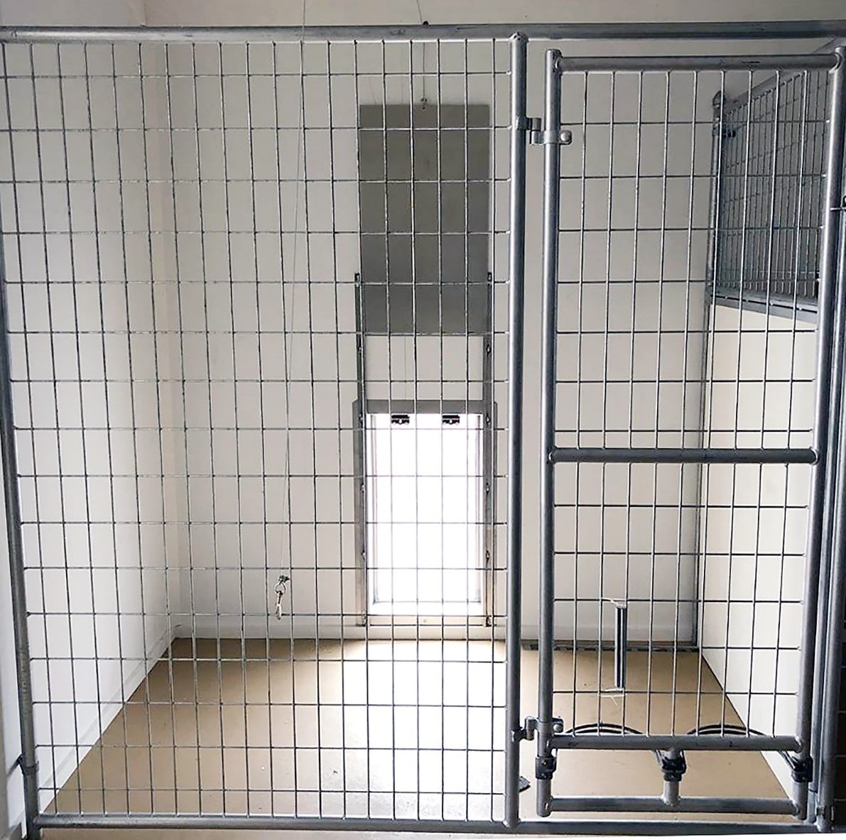 a woman in a green shirt and black gloves vacuuming a gray ottoman