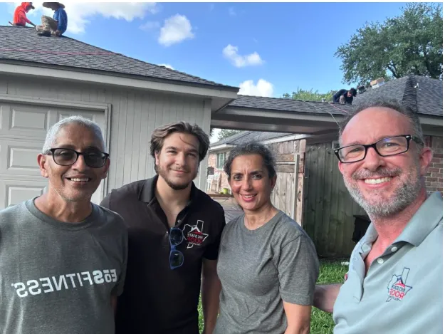 Skycrest Roofing field crew standing next to a company truck, smiling and wearing branded safety gear.