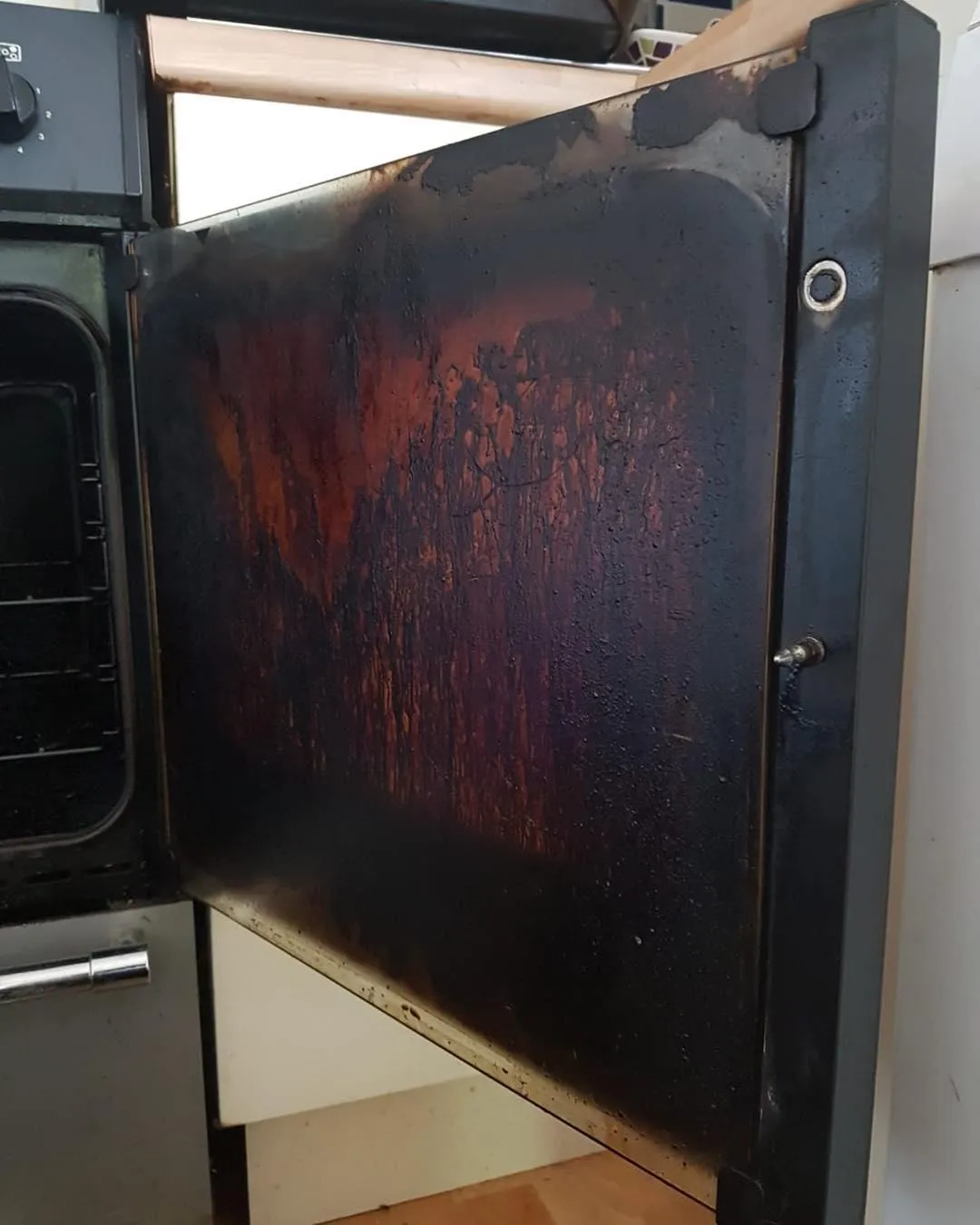 Dirty oven door with a build up of grease and grime, in need of professional cleaning services