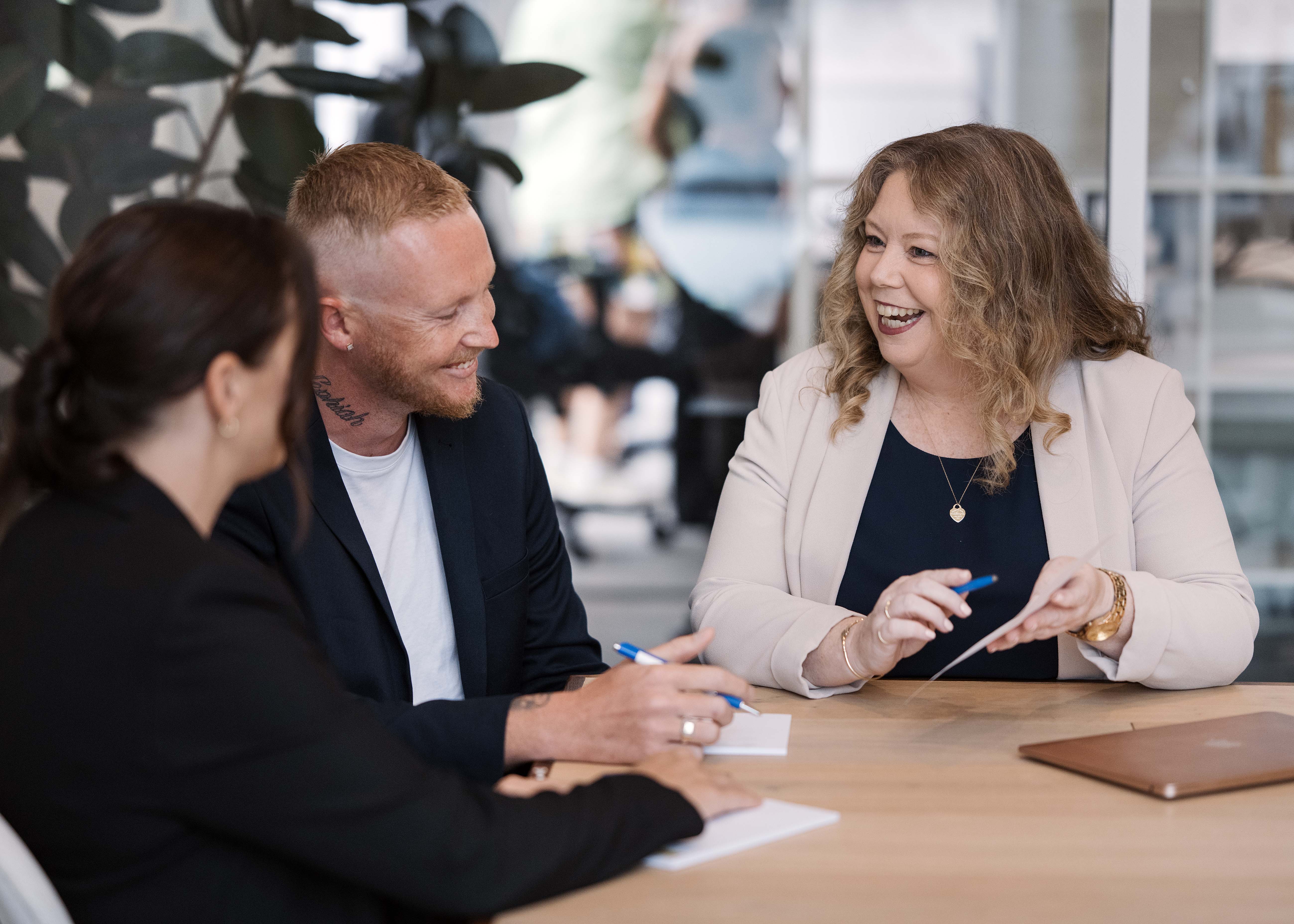 Workshop attendees collaborating over a profit worksheet in a bright Gold Coast room.