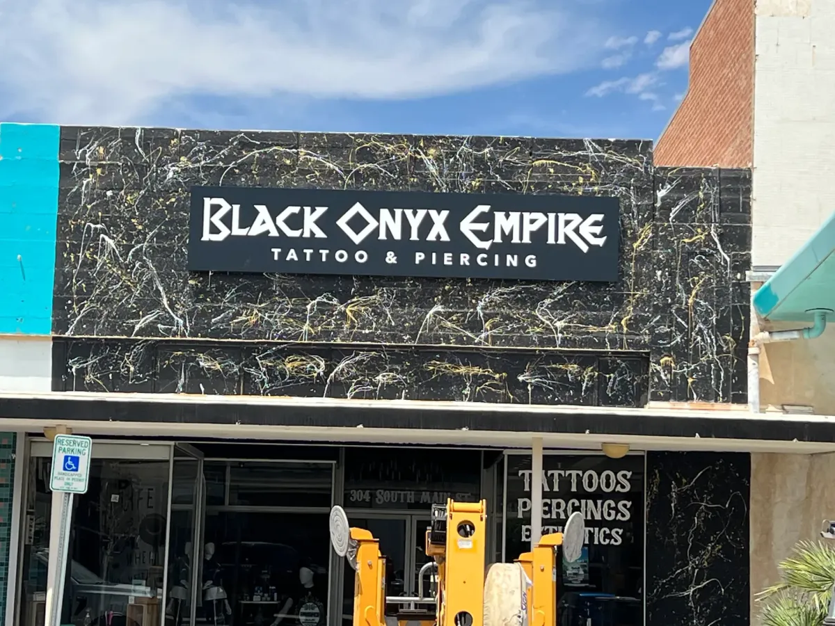Sign above a tattoo shop that reads " Black Onyx Empire"