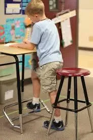 Kids moving with the teacher on a large screen TV